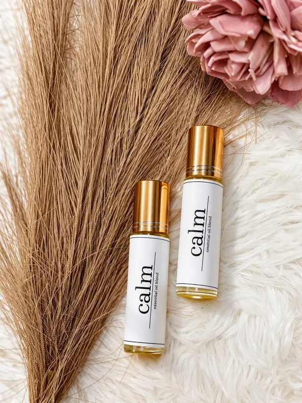Calm essential oil roll-ons styled with dried pampas and a pink flower
