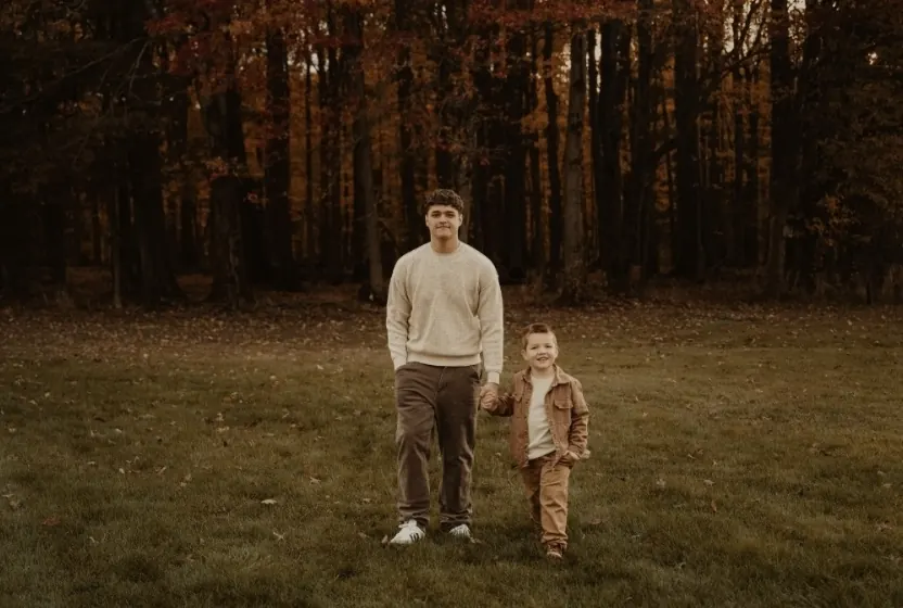 Two of the founder's sons walking together across an autumn field