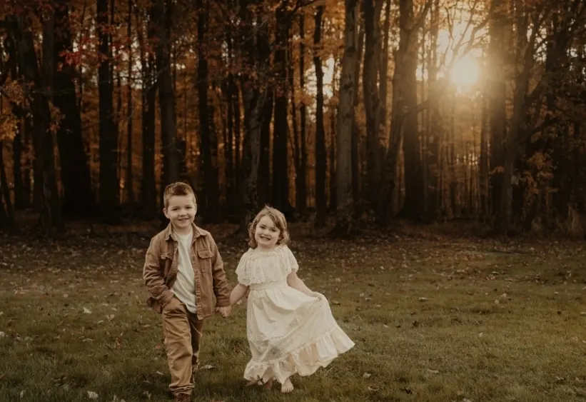 Two of the founder's youngest children walking hand in hand at sunset