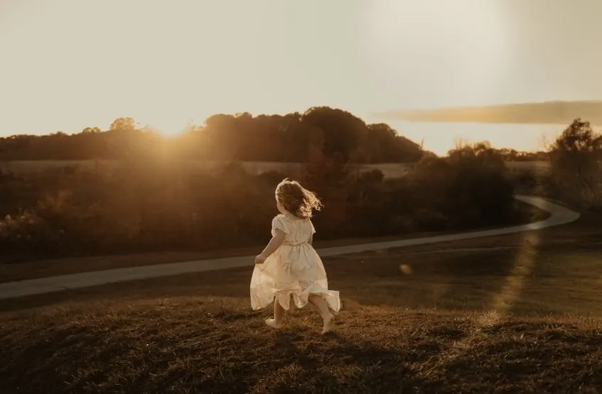 The founder's youngest daughter running barefoot toward the sunset