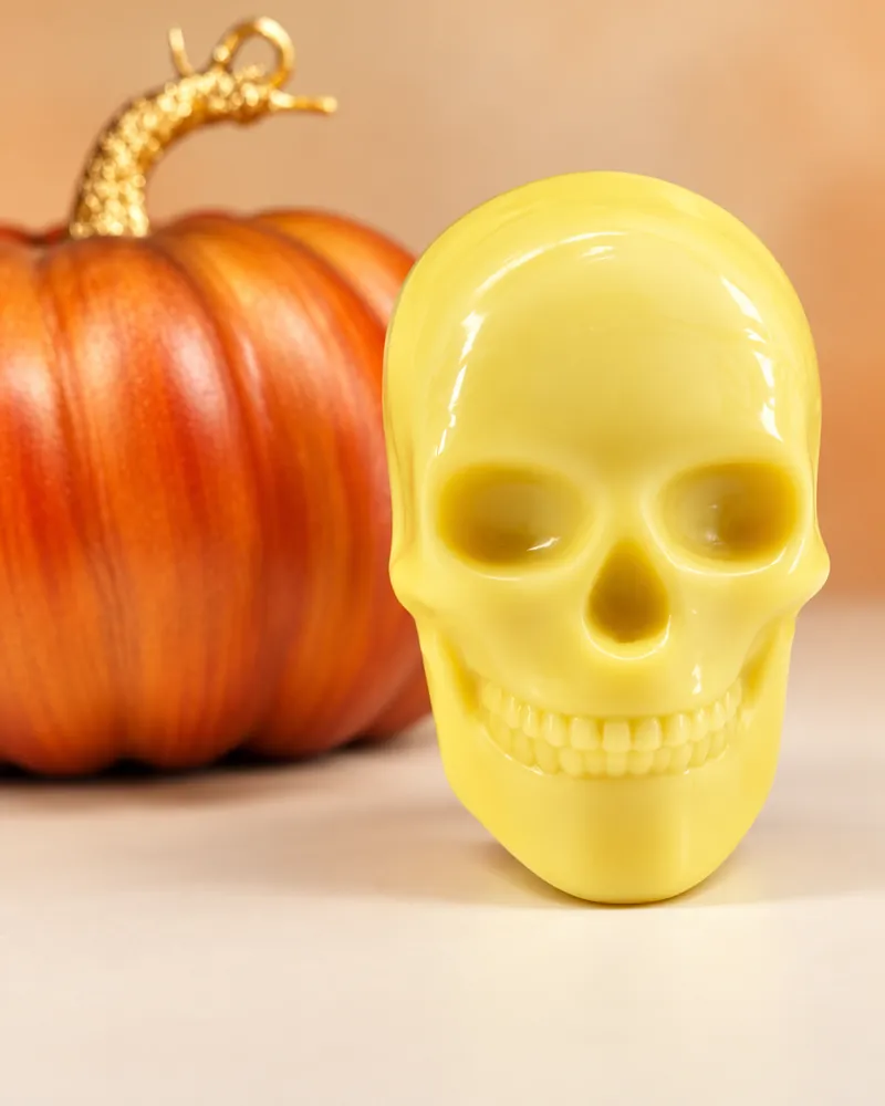 Angel Oh limited edition skull shaped hard lotion bar beside an orange pumpkin